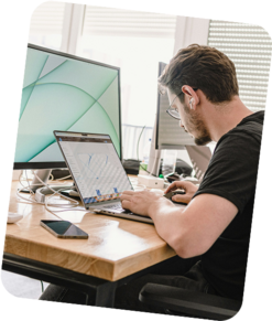 Ein Mitarbeiter sitzt an einem Arbeitsplatz am Laptop